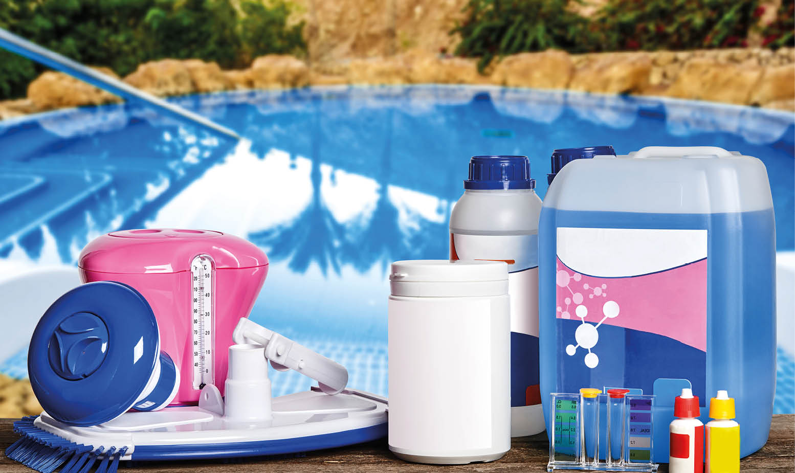Amazing equipment with chemical cleaning products and tools for the maintenance of the swimming pool on wooden surface against a nature background. Descent to the water. Close-up front view.