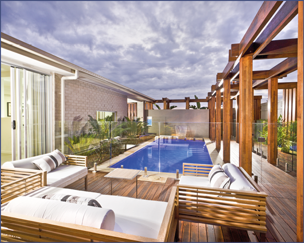 Wood decorated swimming pool area with green plants and glass panel cover under the cloudy sky in a modern house or hotel
