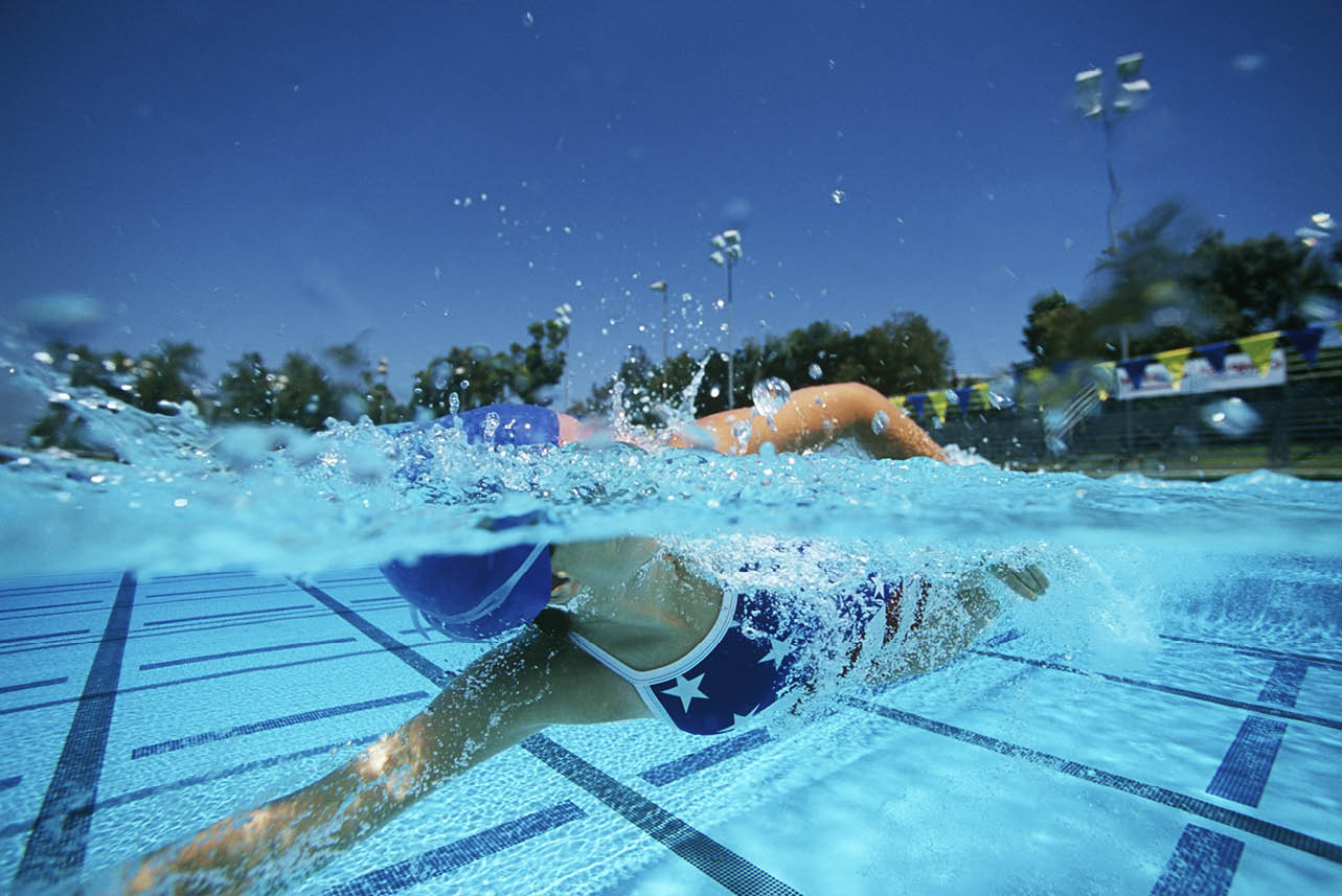 Young Caucasian female swimmer swimming in pool