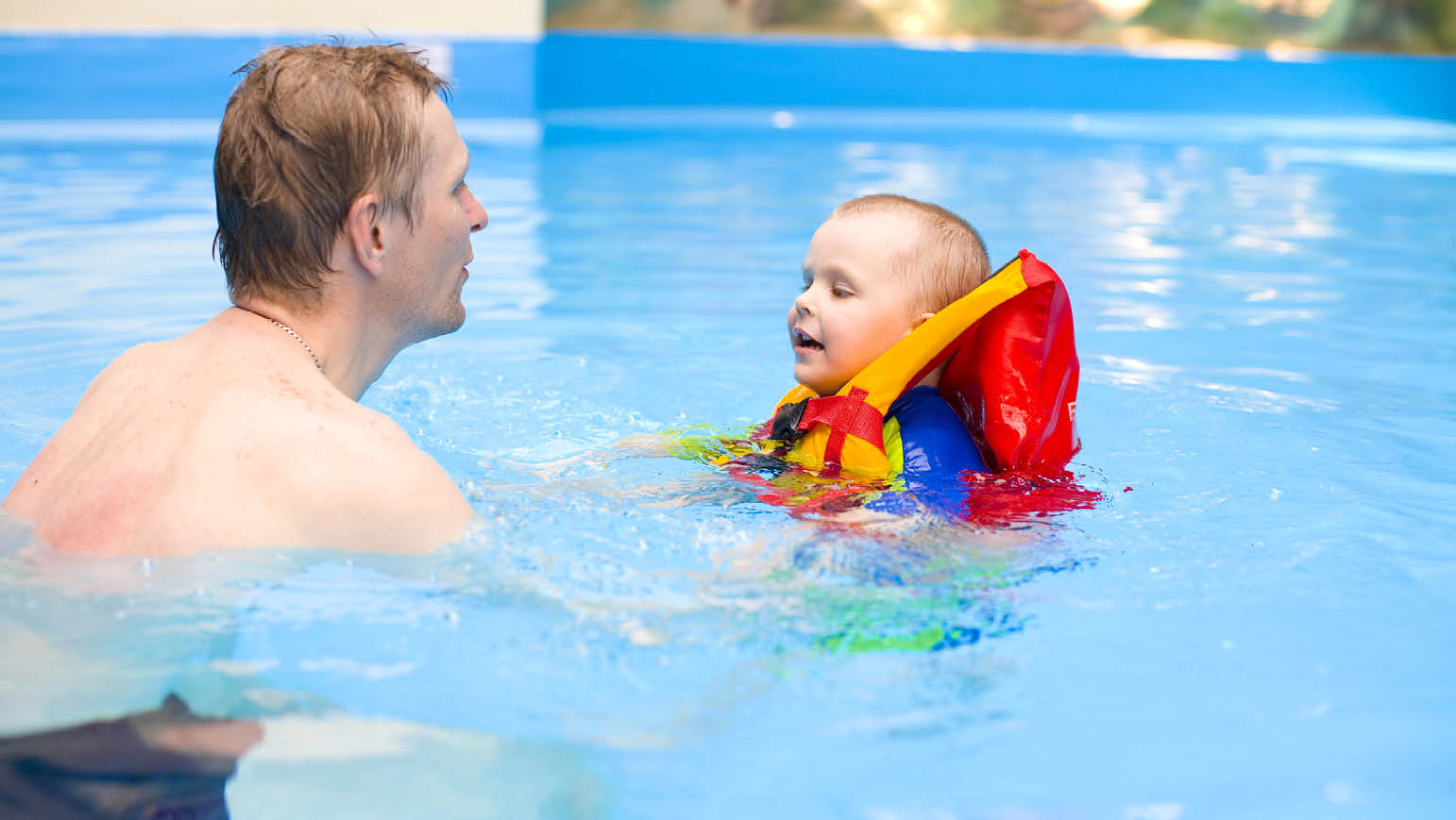 boy of 4 years learns to swim in pool with father