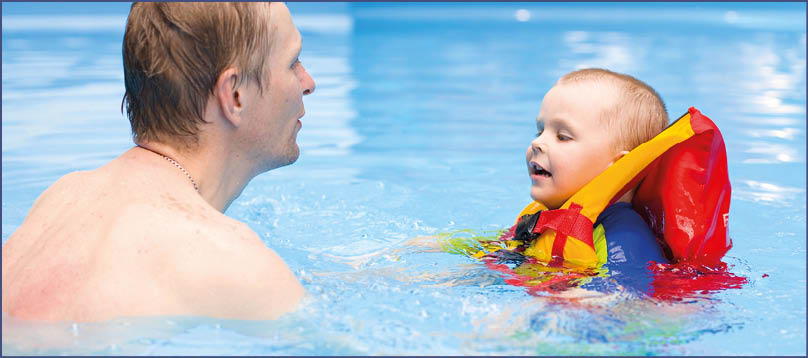 boy of 4 years learns to swim in pool with father